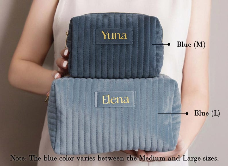 A person holding two gray makeup bags with personalized names on them.