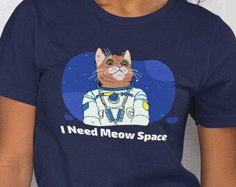 May include: A navy blue t-shirt with a graphic of a cat wearing an astronaut suit and the text "I Need Meow Space".