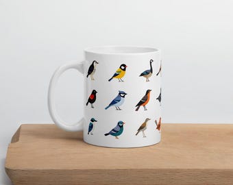 May include: White ceramic mug featuring colorful illustrations of various bird species. The birds are depicted in a cartoon style, with a variety of colors and patterns. The mug has a curved handle and a smooth surface, perfect for enjoying your favorite beverage.