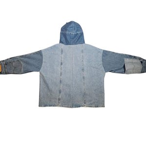 May include: A light and medium blue denim jacket with a hood. The jacket features a patchwork design with different shades of denim. The sleeves have pockets and a brown leather patch. A casual outerwear garment.