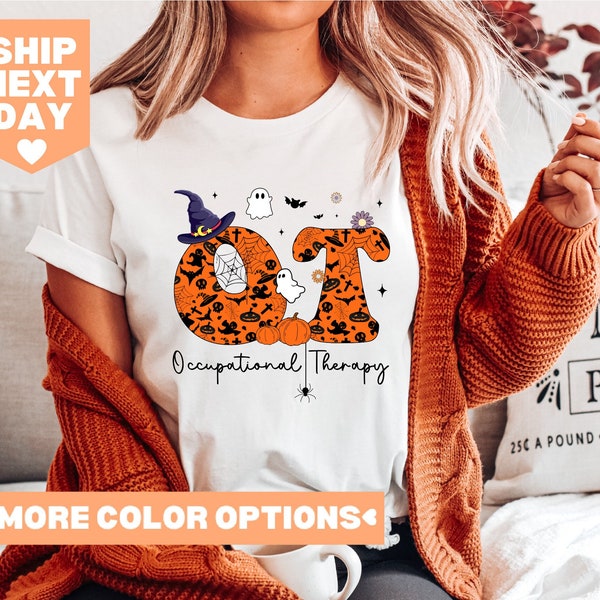 Può includere: Maglietta bianca con una grafica delle lettere "OT" fatte di zucche e disegni a tema Halloween. Le lettere sono circondate da una ragnatela e il testo "Occupational Therapy" è sotto.