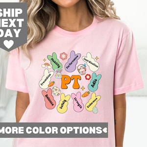 May include: Pink t-shirt with a graphic of Easter eggs and the words "PT" in the center. The eggs have different colors and have words like "Mobility", "Performance", "Coordination", "Prevention", "Balance", "Safety", "Strength", "Endurance", and "Aids" written on them.
