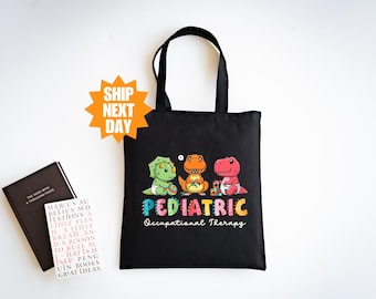 Puede incluir: Bolsa de tela negra con un diseño de tres dinosaurios de dibujos animados y el texto "PEDIATRIC Occupational Therapy".