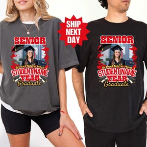 May include: Two t-shirts with a graduation theme. The shirts are black and gray with red and yellow text. The text says "Senior" and "Student Name Year Graduate".