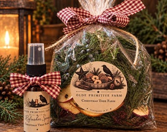 May include: A clear plastic bag filled with evergreen sprigs, dried fruit slices, and a round label reading Olde Primitive Farm Christmas Tree Farm, tied with a red and white gingham bow. Beside it, a spray bottle with a matching label and bow.