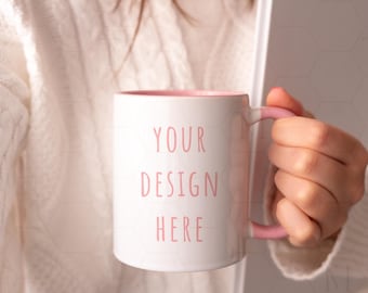 May include: White ceramic mug with a pink rim and handle. The mug has the text "YOUR DESIGN HERE" printed in pink on the front.