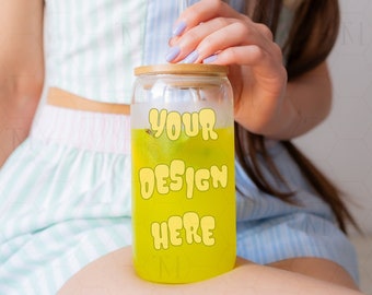 May include: A clear glass tumbler with a bamboo lid and a yellow beverage inside. The tumbler has the text "YOUR DESIGN HERE" printed on it in yellow.