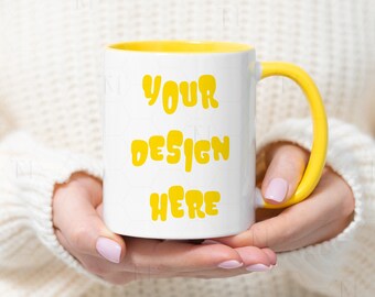 May include: A white ceramic mug with a yellow rim and handle. The mug has the text "YOUR DESIGN HERE" printed in yellow.