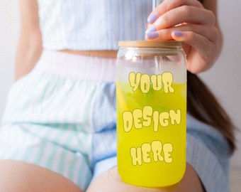May include: A clear glass tumbler with a bamboo lid and a straw. The tumbler is filled with a yellow liquid and has the text "YOUR DESIGN HERE" printed on the front.