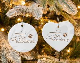 Könnte beinhalten: Zwei weiße Keramik-Weihnachtsbaumschmuckstücke, die an einem Weihnachtsbaum hängen. Ein Ornament ist rund und das andere herzförmig. Beide Ornamente haben den Text "Tita Mockup" und einen braunen Pfotenabdruck.
