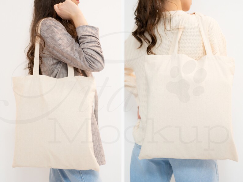 May include: Two people are holding a blank canvas tote bag. The bag is made of natural cotton and has long handles. The bag is a great way to carry your essentials and show off your style.