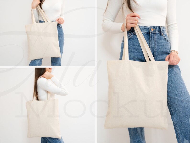 May include: A person is holding a white canvas tote bag with two handles. The bag is empty and has a natural, unbleached look. The person is wearing blue jeans and a white long-sleeved shirt.