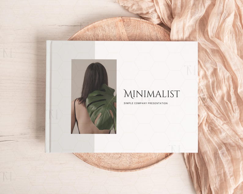 May include: A white presentation book with the text "MINIMALIST SIMPLE COMPANY PRESENTATION" on the cover. The cover also features a photo of a person with a large green leaf behind them.