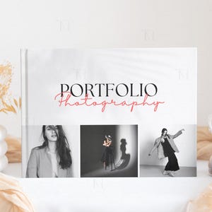 May include: A white portfolio book with the text "PORTFOLIO Photography" in black and red. The book features three black and white photographs of people.