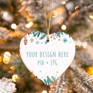 May include: White ceramic heart-shaped ornament with a green and gold Christmas design. The ornament has the text "YOUR DESIGN HERE PSD + JPG" printed on it.