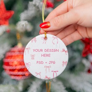 May include: White ceramic Christmas ornament with a pink bow pattern and the text "YOUR DESIGN HERE PSD + JPG".