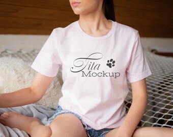 Puede incluir: Una camiseta rosa con el texto "tita mockup" y una huella de pata negra.