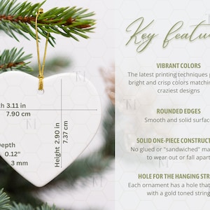 May include: White heart-shaped ornament with gold hanging string, 3.11 inches wide, 2.90 inches high, and 0.12 inches deep. The ornament is hanging on a Christmas tree. Text on the ornament includes measurements in inches and centimeters.