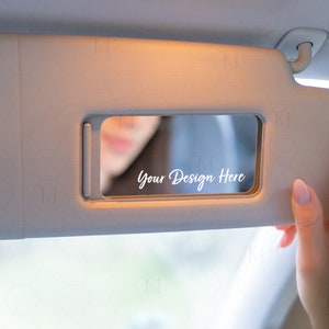 May include: A beige car sun visor with a small mirror that says "Your Design Here" in white text.