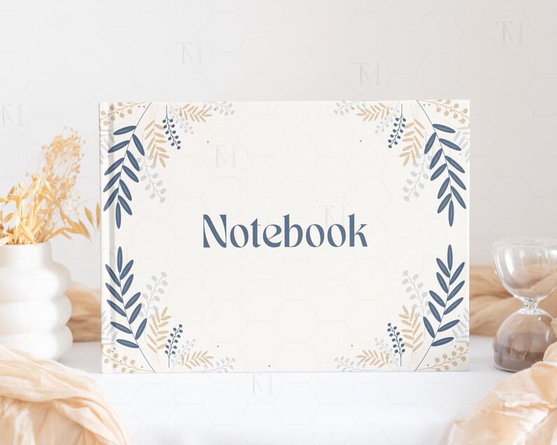 May include: A white notebook with a floral design in shades of blue and beige. The word "Notebook" is printed in the center of the cover.