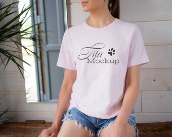 Puede incluir: Una camiseta rosa con una huella de pata negra y el texto "Tita Mockup" impreso en la parte delantera.