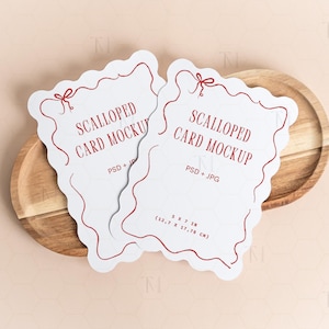 May include: Two white, scalloped-edge cards with red trim and text reading "SCALLOPED CARD MOCKUP" and "PSD + JPG" are displayed on a wooden plate. The cards measure 5 x 7 inches (12.7 x 17.78 cm).
