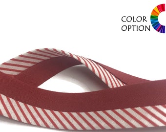 May include: Red and white striped ribbon with a solid red underside. The ribbon is folded in half, creating a loop.