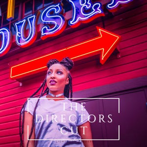 May include: A woman with long braids and a white t-shirt stands in front of a red building with neon signs. The signs read "HOUSE" and an arrow pointing to the right. The text "THE DIRECTORS CUT LIGHTROOM PRESET" is superimposed on the image.