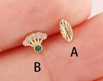 May include: Two gold earrings, one with a green stone and white stones in a fan shape, and the other a simple oval shape.