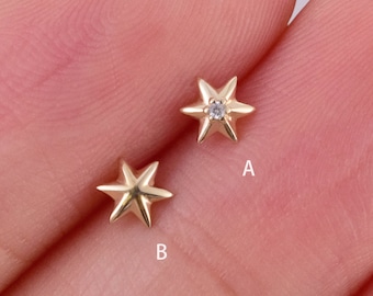 May include: Two gold star-shaped earrings, one with a small diamond in the center. The earrings are labeled A and B.