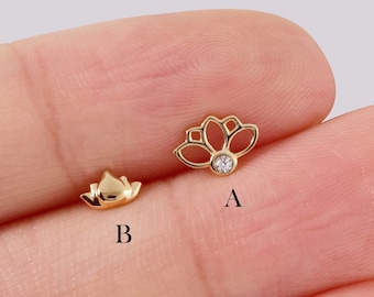 May include: Two gold lotus flower earrings, one with a clear gemstone in the center. The earrings are labeled A and B.