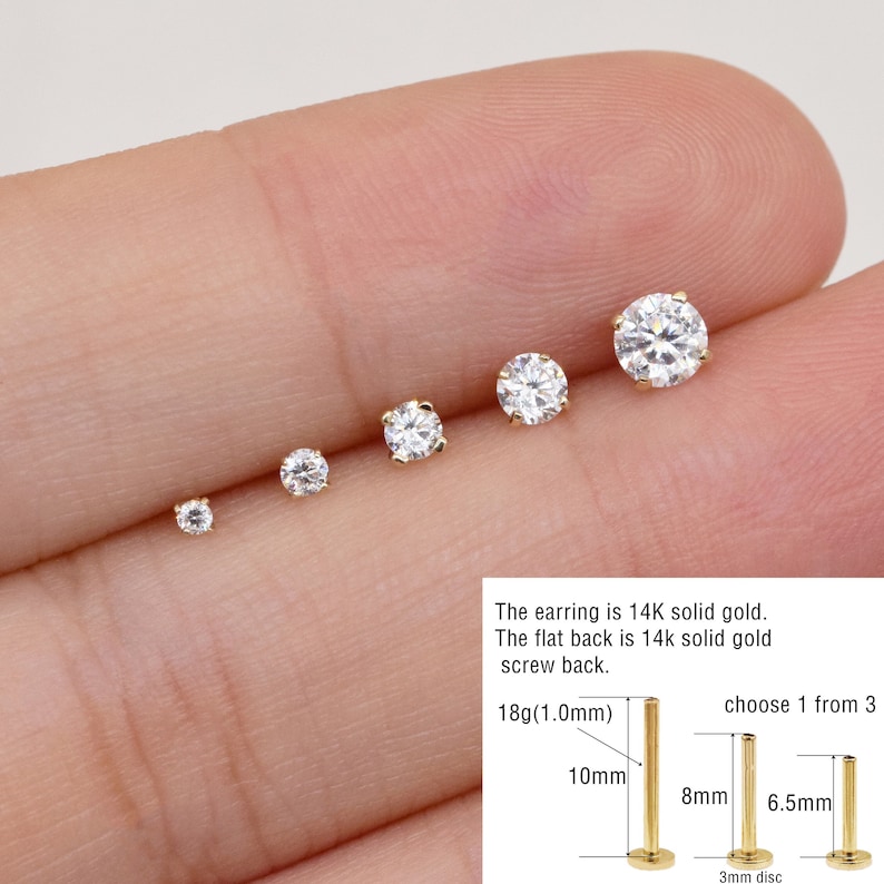 May include: Five different sizes of gold nose studs with clear round gemstones. The earring is 14K solid gold. The flat back is 14k solid gold screw back. 18g(1.0mm) 10mm 8mm 6.5mm 3mm disc