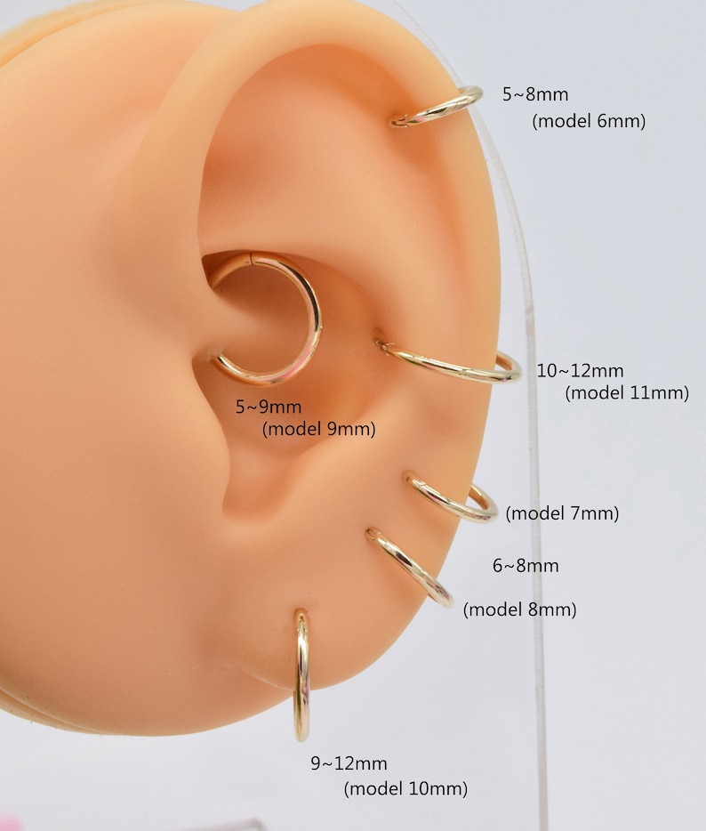 May include: A gold-toned hoop earring set displayed on a synthetic ear model. The image includes text labels for sizing: 5-8mm (model 6mm), 10-12mm (model 11mm), 5-9mm (model 9mm), 6-8mm (model 7mm), 6-8mm (model 8mm), and 9-12mm (model 10mm).