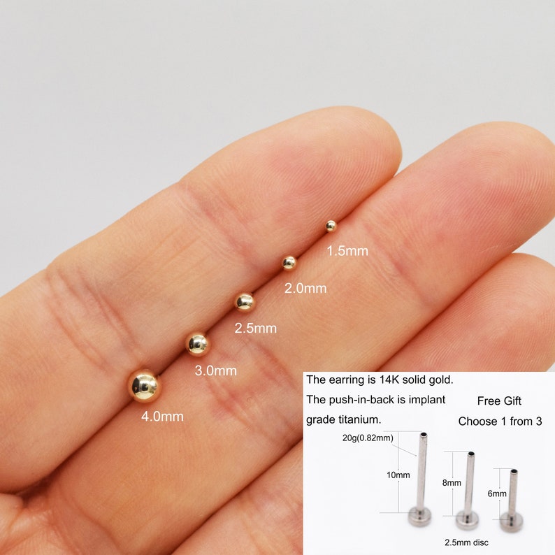 Pu&ograve; includere: Un set di orecchini a sfera dorati in diverse dimensioni, che vanno da 1,5 mm a 4,0 mm. Gli orecchini sono realizzati in oro massiccio 14 carati e hanno un retro a pressione in titanio di grado implantabile. L'immagine mostra anche tre diverse dimensioni di retro a pressione, 6 mm, 8 mm e 10 mm, con un disco di 2,5 mm.