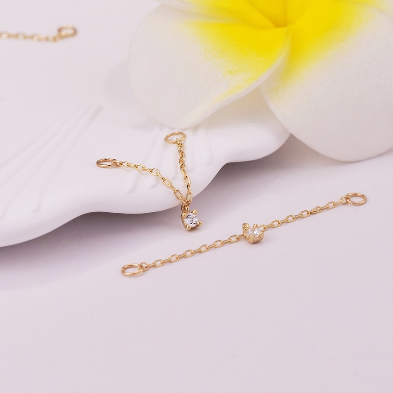 May include: Two gold chains with small diamond accents. The chains are designed to be used as extenders for necklaces or bracelets.
