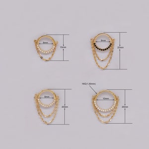May include: Four gold hoop earrings with dangling chains. The hoops are 8mm and 10mm in diameter. The chains are adorned with small clear or black gemstones. The earrings are 15mm or 20mm long.