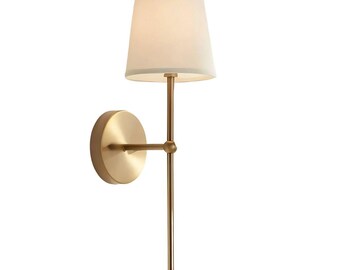 Könnte beinhalten: Goldfarbene Wandleuchte mit weißem Lampenschirm. Die Leuchte hat eine kreisförmige Wandhalterung, einen horizontalen Arm und eine vertikale Stange, die in einer kleinen Kugel endet. Der Lampenschirm ist aus konischem, cremefarbenem Stoff.