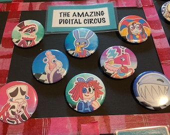 Puede incluir: Una colección de botones redondos de colores con personajes de dibujos animados. Los botones están dispuestos sobre un fondo negro con cinta rosa y blanca. El texto "THE AMAZING DIGITAL CIRCUS" está impreso en un cartel azul y blanco.
