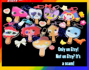 May include: A collection of acrylic popsicle-shaped keychains featuring various colorful character designs, including a crying face, a red-haired figure, and a monster mouth. The text reads COOPER BUTTER STUFF and Only on Etsy! Not on Etsy? It's a scam!