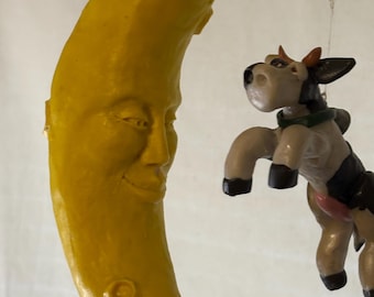 whimsical cow jumping over the moon