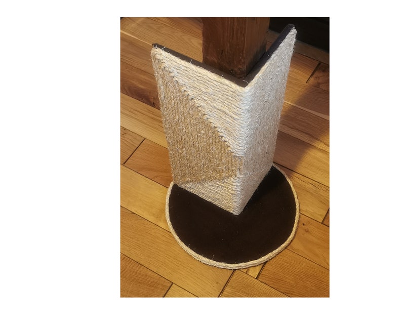 May include: A beige and white sisal-wrapped corner cat scratching post with a black circular base. The post is designed to be attached to a corner of a room.