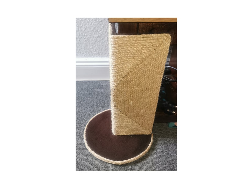 May include: A brown and beige cat scratching post with a round base. The post is covered in sisal rope and the base is covered in brown fabric.