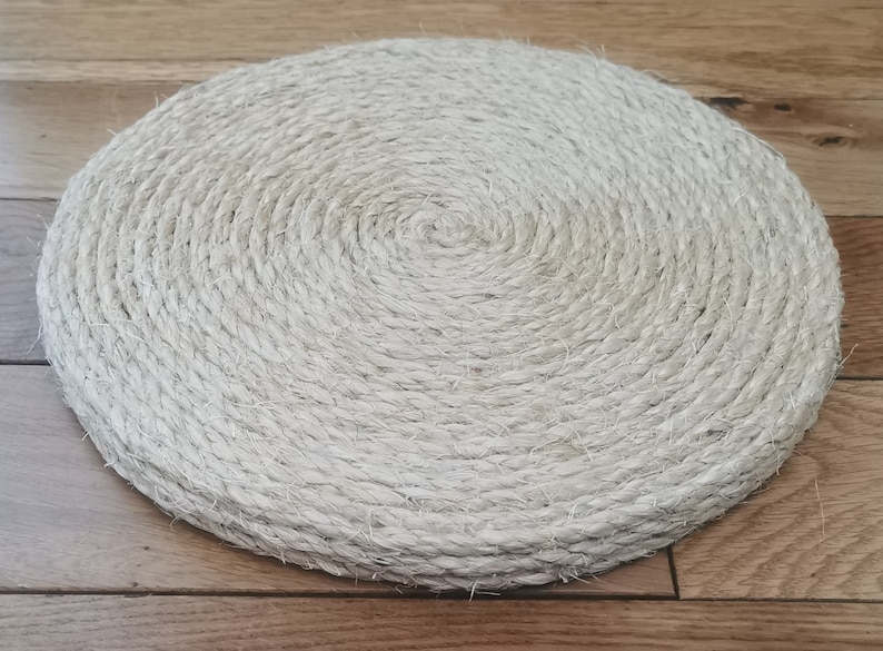 May include: A round, beige, woven coaster made from natural rope.