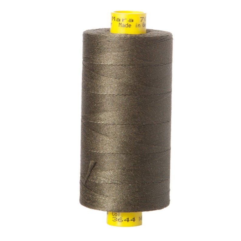 May include: A spool of dark green thread with a yellow label that reads "Mara 70 Made in Germany Col. 3644 14"