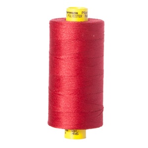 May include: A spool of red sewing thread with a yellow label that reads "Polyester Made in Germany" and "Col. 46".