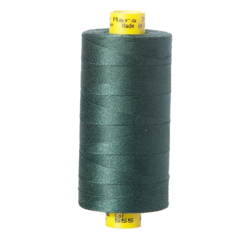 May include: A spool of dark green thread with yellow labels that read "Mara 7" and "Col. 555"