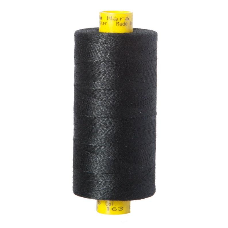 May include: A spool of black thread with a yellow label that reads "Mara" and "Made in Italy". The label also has the number "163" on it.