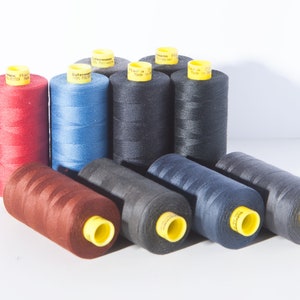May include: A collection of spools of thread in various colors, including red, blue, brown, and black. The spools are arranged in a pyramid shape, with the largest spool at the bottom and the smallest spool at the top.