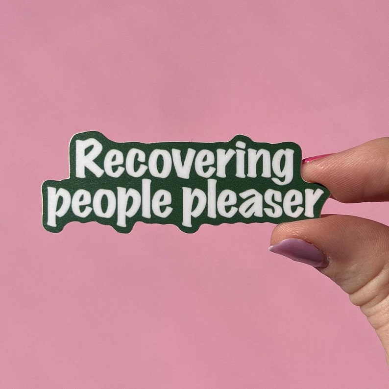 May include: Green sticker with white text that reads "recovering people pleaser".