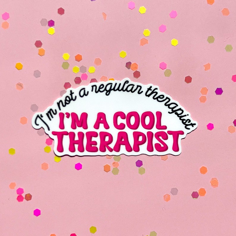 May include: White sticker with pink text that reads "I'm not a regular therapist I'm a cool therapist". The sticker is on a pink background with colourful confetti.